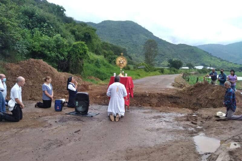 The priest prays in front of one of the ditches dug by armed groups to block access to Coalcomán.