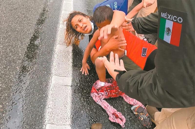 A migrant woman and her child on the ground during Saturday's confrontation.