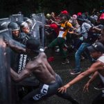 Migrants attempt to force their way past National Guardsmen in Chiapas on Saturday.