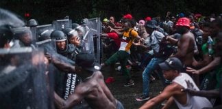 Migrants attempt to force their way past National Guardsmen in Chiapas on Saturday.
