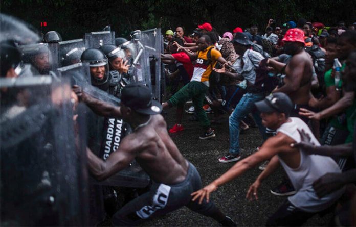 Migrants attempt to force their way past National Guardsmen in Chiapas on Saturday.