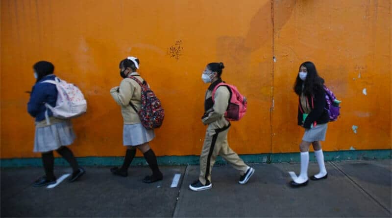 Face masks in place, students make their way to school Monday morning.