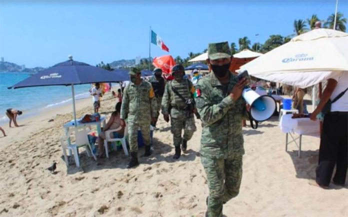 Soldiers patrol an Acapulco beach earlier this year to remind visitors to follow coronavirus precautions.