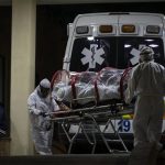 Hospital staff transfer a COVID-19 patient, last December.