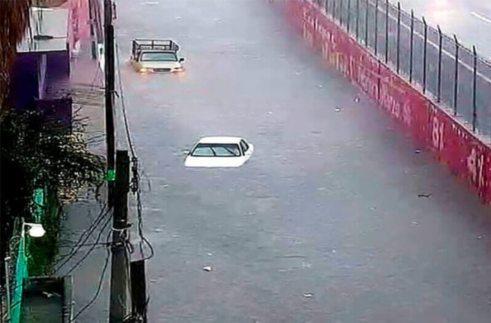 Nearly submerged vehicles on a road in Ecatepec.