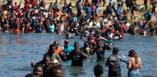 Migrants cross the Rio Grande from Texas back into Mexico to get food and other supplies.