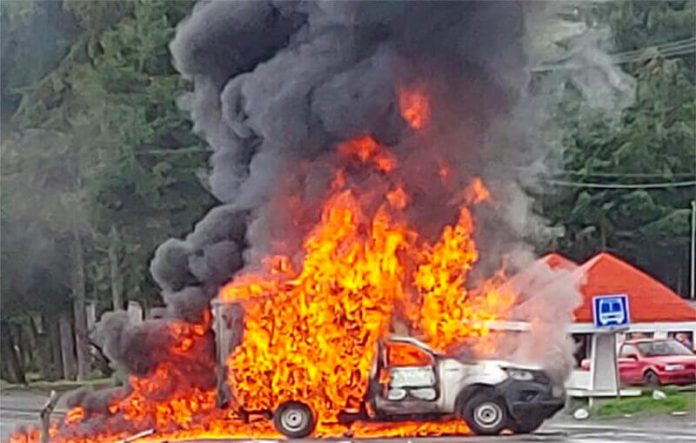 A delivery truck burns at a highway blockade in Michoacán