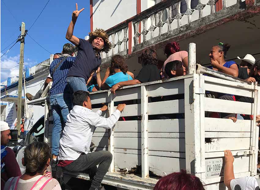 migrants hitching ride on passing truck in Chiapas