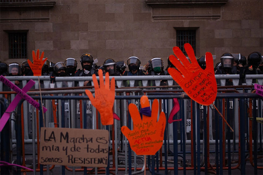 Police stand behind barriers and hand written signs at the protest in Mexico City.