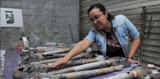 Archaeologist Mara Abigaíl Becerra with artefacts from the altar.