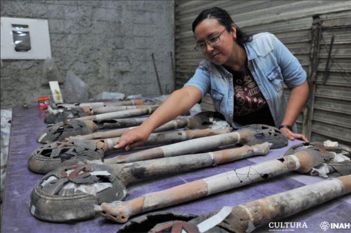 Archaeologist Mara Abigaíl Becerra with artefacts from the altar.