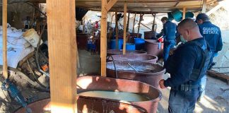 Security officials examine a seized narco lab.