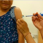 A public health nurse administers a flu shot