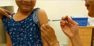 A public health nurse administers a flu shot