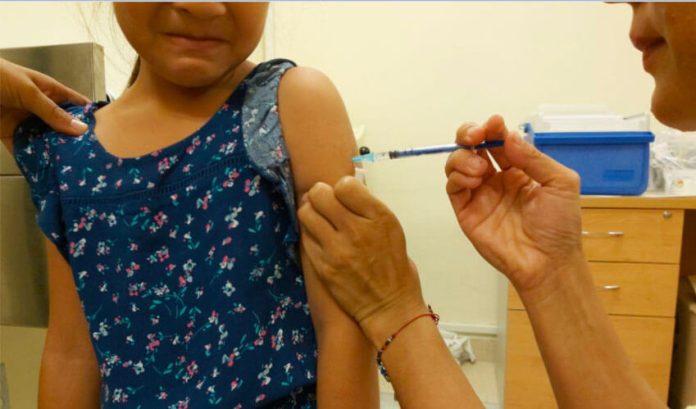 A public health nurse administers a flu shot