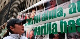 Margarita López, the founder of Buscando Cuerpos, in front of a banner commemorating disappeared people.