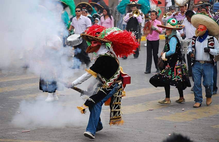 Zacapoaxtla costume firing a mock rifle with real gunpowder in Huejotzingo, Puebla