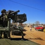 A soldier stands guard while Palma Alta residents pack up their belongings.