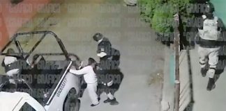 A National Guardsmen pulls a woman by the hair