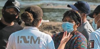 An INM agent speaks with migrants near the Mexico-US border.