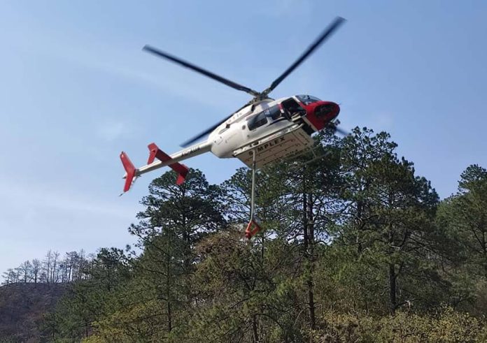 Helicopter spreading fire retardant in Nuevo Leon, Mexico
