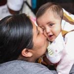 Mexican mom kissing baby