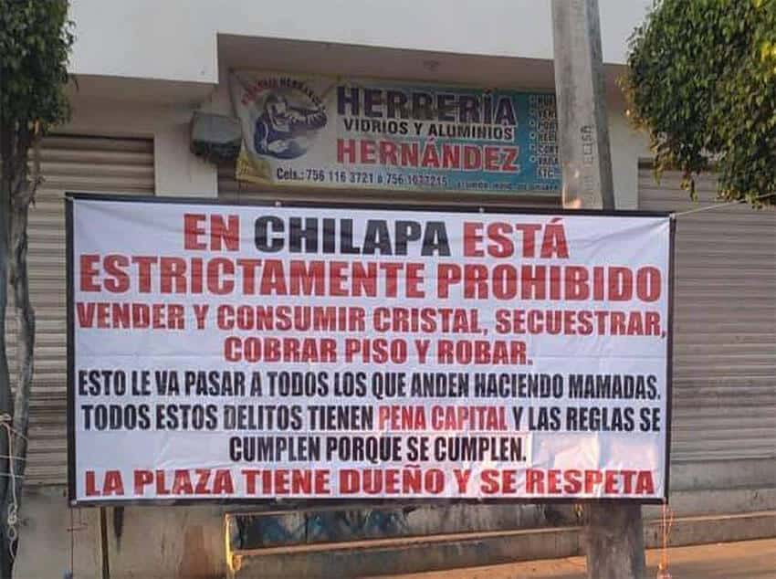 A banner left near the severed heads laid out <i>plaza</i> rules that residents are expected to follow. A <i>plaza</i> is a geographical area controlled by a cartel or a sub-unit of a cartel's area of influence.