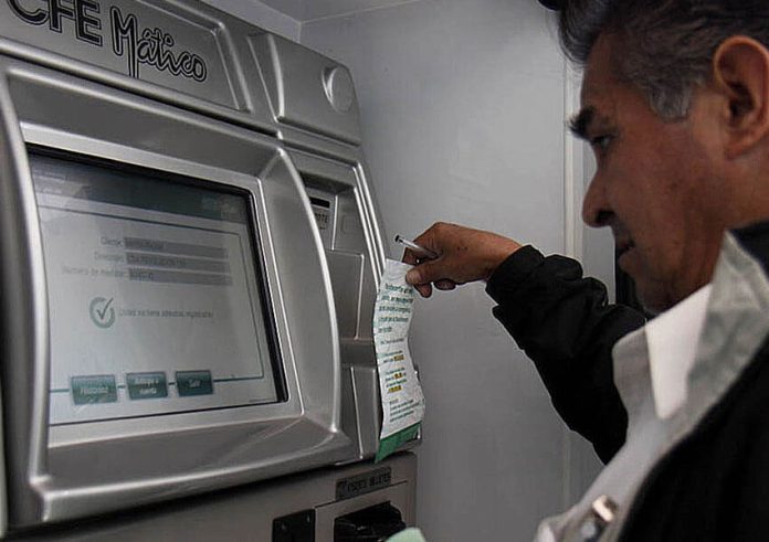 A man pays an electricity bill at a CFE machine.