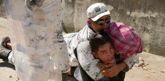 A National Guardsman wrestles a migrant to the ground.