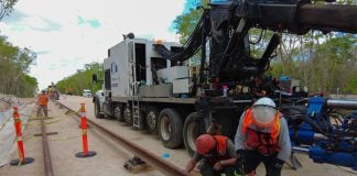 Workers lay track for the Maya Train.