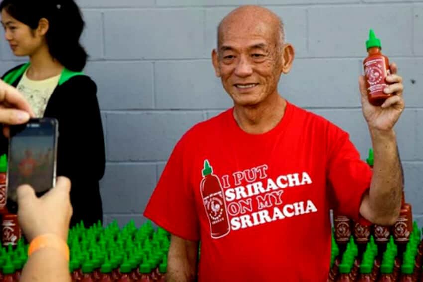 David Tran holds a bottle of his iconic hot sauce.