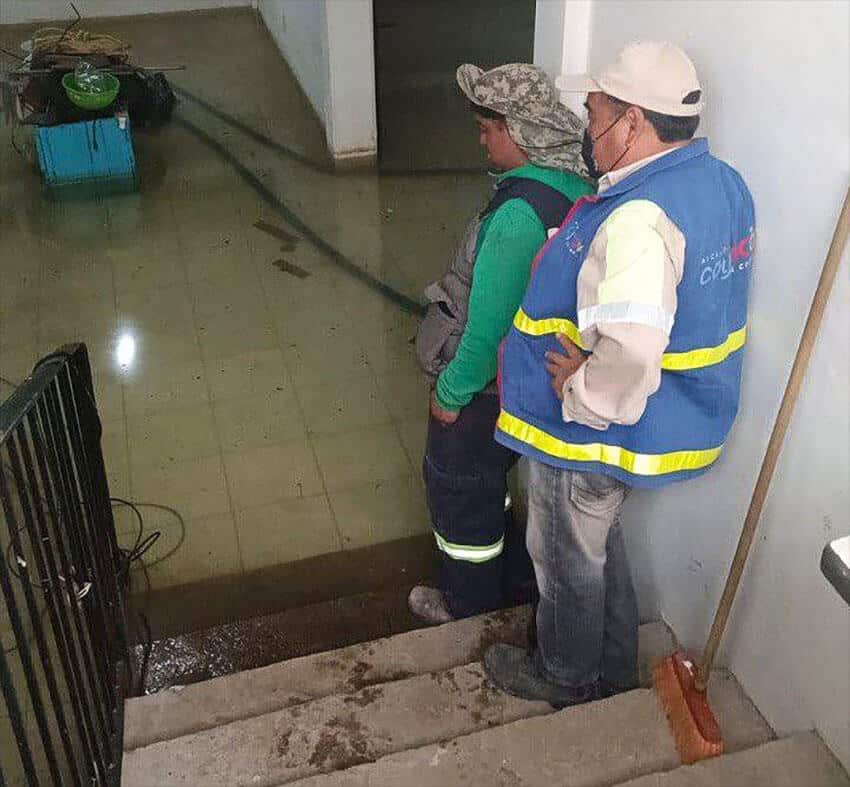City workers inspect a flooded building in the Santa Úrsula neighborhood.