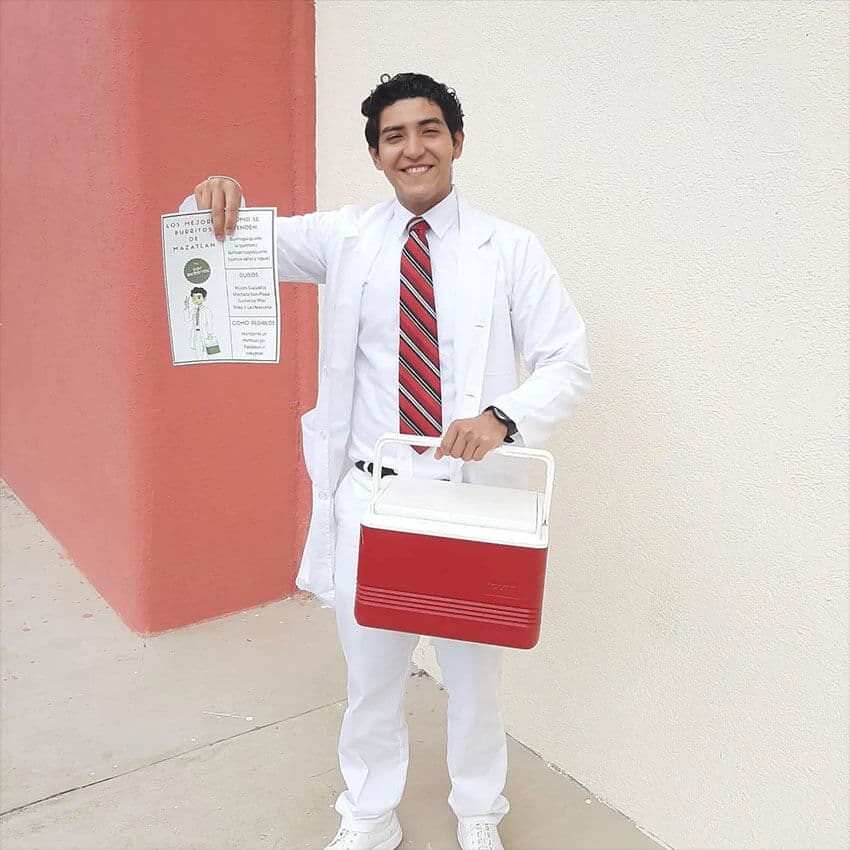 Ángel Santoyo poses with a flyer and a cooler full of burritos.