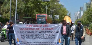Protesters carry a sign saying that the demonstrations were caused by "the CDMX government for not fulfilling agreements regarding the fare increase," and apologizing to the general public for the traffic "chaos."