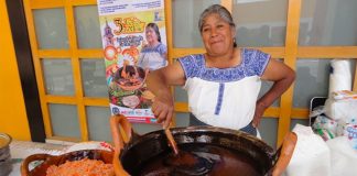 A woman stirs a pot of mole at a fair in San Lucas Atzala