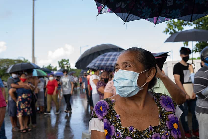  In line to receive the second dose of the Pfizer vaccine, Dulce Maria explained that a woman had stopped by her house on her way to Cancun to get vaccinated, and she decided to go too. Dulce Maria had been isolated in her house in a rural area during the entire pandemic, and was excited to be able to start leaving the house safely again.