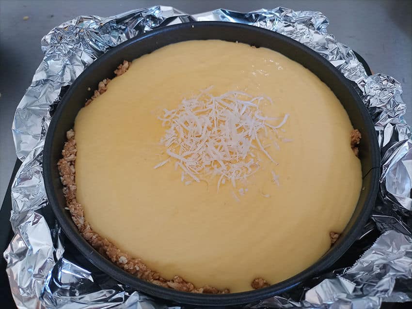 Unbaked cheesecake in an aluminum foil "nest"