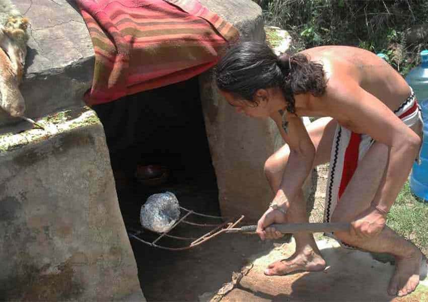putting hot volcanic rocks into a Mexican temazcal