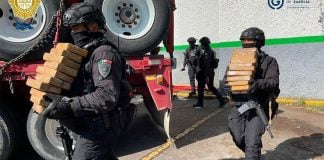 Police unload packages of smuggled cocaine.