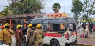 Firefighters extinguish a blaze in a public transit vehicle in Zihuatanejo