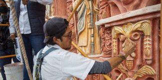 A restorationist at work on the mission's facade