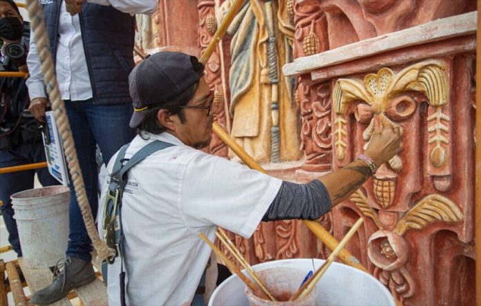A restorationist at work on the mission's facade