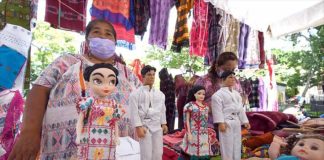 Artisans display the Xochistlahuaca Barbie and Ken dolls in traditional dress, along with other products.