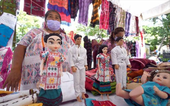 Artisans display the Xochistlahuaca Barbie and Ken dolls in traditional dress, along with other products.