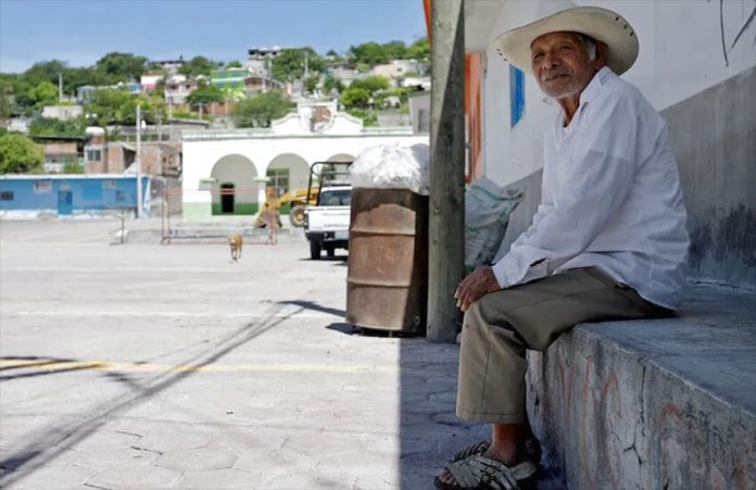 A man sits in the central plaza of Xoyatla, Puebla.