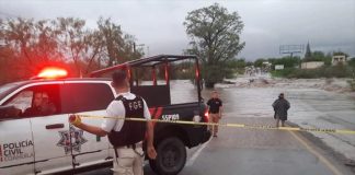 State officials close a flooded road in Múzquiz, Coahuila.
