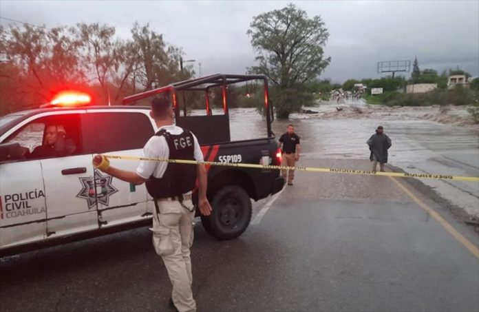 State officials close a flooded road in Múzquiz, Coahuila.