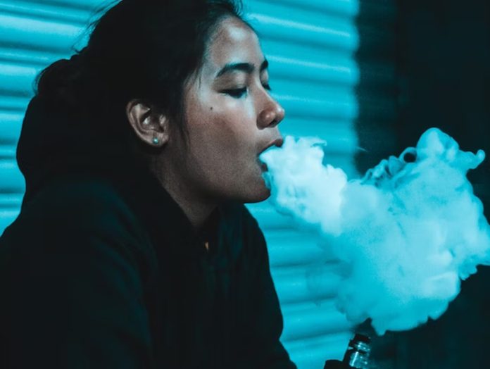 Mexican woman vaping on the street