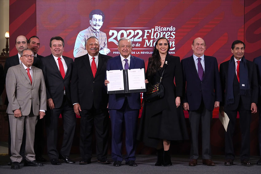 President López Obrador, posing with government officials and business leaders, displays the new agreement at his Monday morning press conference.