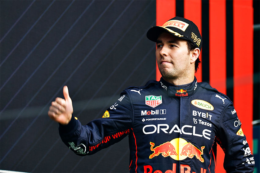 Checo Pérez in his Red Bull/Oracle uniform, giving a thumbs up.